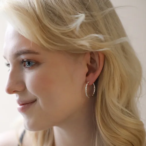 Model Wearing Textured Hoop Earrings in Silver Head Turned to Side