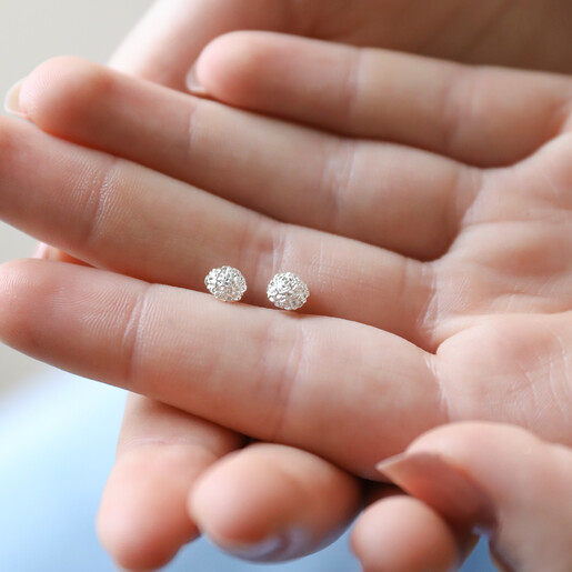 Model Holding January Carnation Tiny Birth Flower Stud Earrings in Silver