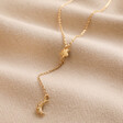 Crystal Moon and Star Lariat Necklace in Gold on Beige Fabric
