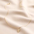 Evil Eye Diamond Pendant Necklace in Gold Full Length on Cream Coloured Fabric