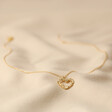 Floral Heart Pendant Necklace in Gold Full Length on Cream Coloured Fabric