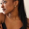 Model Wearing Hammered Halo Pendant Necklace in Gold Layered with Other Gold Necklaces