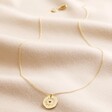 Heart Disc Pendant Necklace in Gold Full Length on Beige Fabric