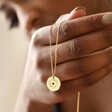 Model Holding Heart Disc Pendant Necklace in Gold