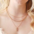 Model Wears E Irregular Pearl Initial Necklace in Gold Stacked With Other Gold Necklaces
