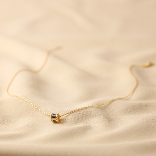 Full Length of Moon Phase Enamel Pendant Necklace in Gold on Natural Coloured Fabric