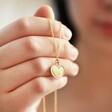 Model Holding Pink Enamel Heart Pendant Necklace in Gold in Hand