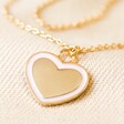 Close Up of Pendant on Pink Enamel Heart Pendant Necklace in Gold on Cream Fabric