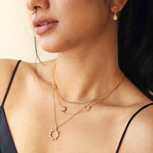 Rainbow Crystal Sunburst Pendant Necklace in Gold on Model Worn With Other Necklaces