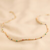 Rainbow Enamel Double Ball Chain Necklace in Gold on Cream Fabric Backdrop