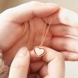 Model Holding Red Enamel Heart Pendant Necklace in Gold in Hands
