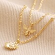 Set of 2 Daisy and Bee Necklaces in Gold Layered on Beige Fabric