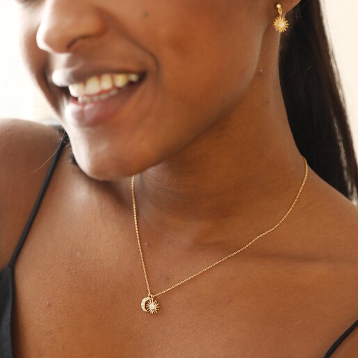 Close Up of Sun and Moon Charm Necklace in Gold on Model