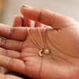 Model Holding Sun and Moon Charm Necklace in Gold