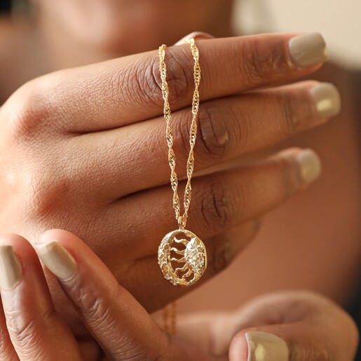 Model Holding Sun and Moon Pendant Necklace in Gold 