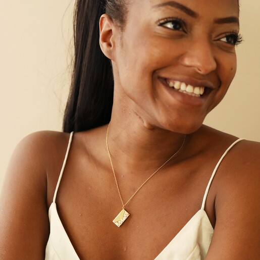 Smiling Model Wearing Wildflower Envelope Locket Pendant Necklace in Gold