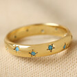 Star Crystal Ring in Gold on a Beige Coloured Fabric