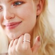 Model Wearing White Enamel Crystal Ring in Gold with Hand on Chin