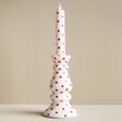 White and Red Spotty Candlestick Candle on Neutral Background