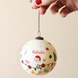 Colourful Hand-Painted Festive Christmas Bauble Held by Model