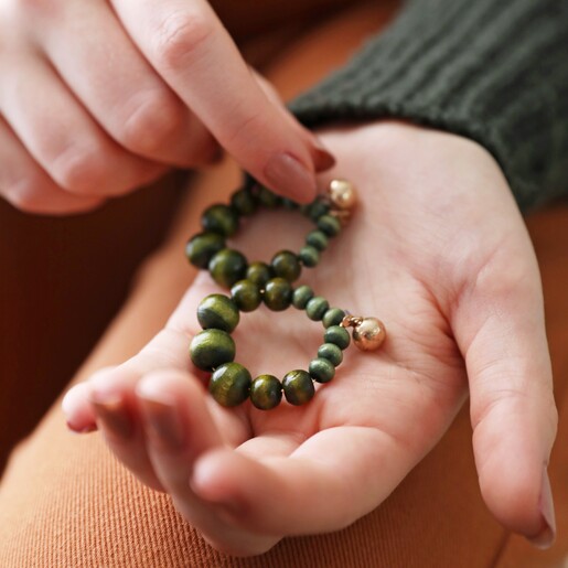 Model Holding Green Wooden Bead Drop Earrings