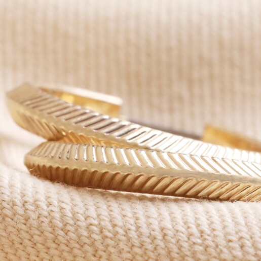 Close Up of Herringbone Edge Hoop Earrings in Gold Laid on Natural Fabric