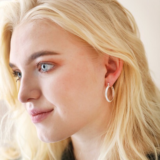 Model Wearing Herringbone Edge Hoop Earrings in Silver Against Neutral Backdrop