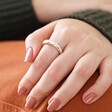 Matte Hammered Organic Ring in Silver on Model with Hand on Orange Cushion