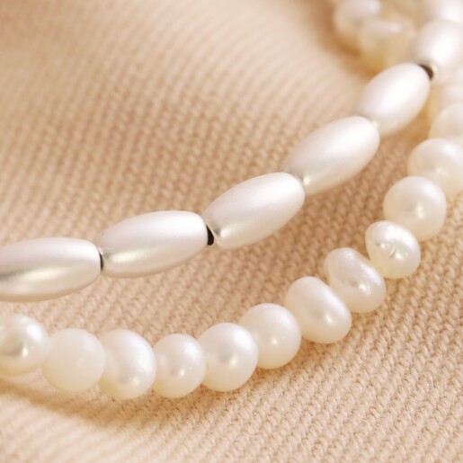 Close Up of Pearl and Matte Bead Layered Bracelet in Silver on Natural Coloured Fabric