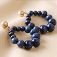 Wooden Bead Drop Earrings in Navy Laid Out on Neutral Coloured Fabric