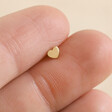 Model Holding Tish Lyon Solid Gold Heart Barbell Between Fingers