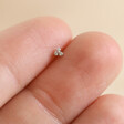 Model Holding Tish Lyon White Gold Tiny Crystal Trinity Nose Stud in Between Finger Tips