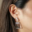 Close Up of Big Metal London Cosette Gemstone Drop Earrings in Blue on Model
