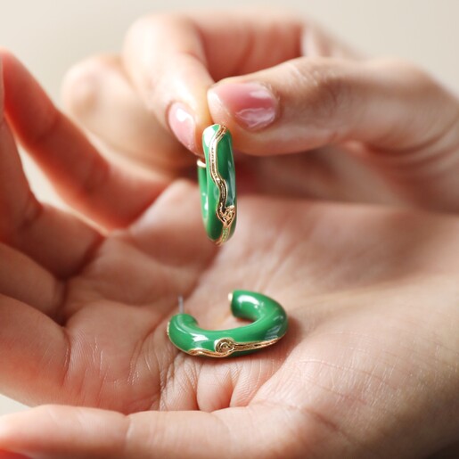 Model Holding Big Metal London Engraved Edge Green Enamel Hoop Earrings in Gold