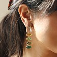 Close Up of Model Wearing Big Metal London Green Stone Cut Luxe Earrings in Gold