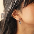 Close Up of Model Wearing Big Metal London Grey Stone Luxe Drop Earrings in Gold