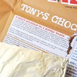Showing Tony's Sweet Solution on Inside of Packaging in Tony's Chocolonely Milk Caramel Biscuit Chocolate Bar