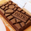Unwrapped Tony's Chocolonely Milk Caramel Biscuit Chocolate Bar on Packaging