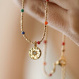 Model Holding Estella Bartlett Crystal Rainbow Pendant Necklace in Gold in Hand