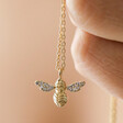 Model Holding Estella Bartlett Cubic Zirconia Bee Pendant Necklace in Gold