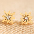 Estella Bartlett North Star Crystal Stud Earrings on Beige Fabric