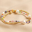 Estella Bartlett Pack of 2 Gold & Multicolour Beaded Bracelets on Beige Fabric