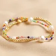 Estella Bartlett Pack of 2 Gold & Multicolour Beaded Bracelets on Beige Fabric