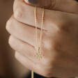 Model Holding Estella Bartlett North Star Pendant Necklace in Gold