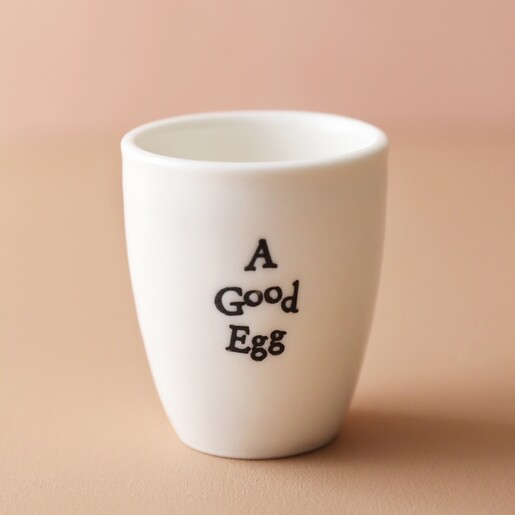 East of India Good Egg Porcelain Egg Cup Empty Against Pink Background
