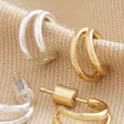 Double Illusion Huggie Hoop Earrings in Gold and Silver on Beige Fabric