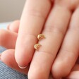 Model Holding Tiny Crescent Moon Stud Earrings in Gold