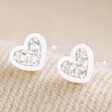 Tiny Crystal Heart Stud Earrings in Silver on Beige Fabric