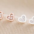 Tiny Crystal Heart Stud Earrings in Silver and Rose Gold on Fabric