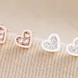 Tiny Crystal Star Stud Earrings in Rose Gold and Silver on Beige Fabric